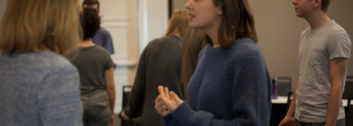 A woman standing in front of other people.